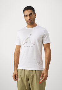 Fehér pamut póló színes Jordan logóval és "sport" felirattal. Rövid ujjú, kerek nyakú és szokásos szabású.