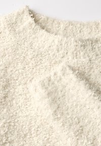 Biała, teksturowana, dziana sweter z puszystą powierzchnią; posiada klasyczny okrągły dekolt i miękką, puszystą włóczkę. Idealny do noszenia na cebulkę.