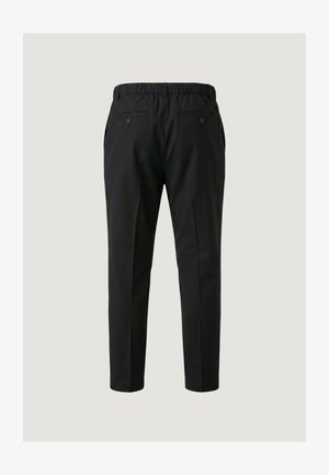 Pantalon noir sur mesure avec taille élastique et poches arrière boutonnées, vu de dos sur un fond gris clair.