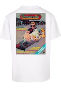 Hvit T-skjorte med et fargerikt grafisk design av et vintage skateboardmagasinforside på ryggen, med detaljer om skateboardingartikler og tips.