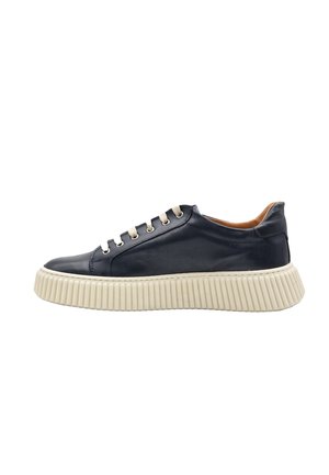 Sneaker in pelle nera low-top con suola bianca spessa e rigata e lacci beige, vista laterale su sfondo bianco.