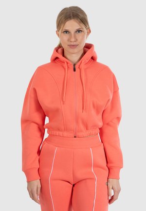 Koraalrode zip-up hoodie met een ontspannen fit, elastische tailleband en twee opgestikte zakken. Voorzien van een textuurstof en capuchon met trekkoord.