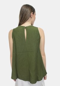 Top verde senza maniche realizzato in tessuto leggero, presenta una schiena a chiave con chiusura a bottone e una forma rilassata e fluida.