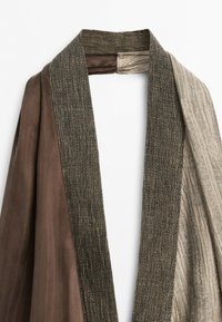 Robe marron et beige avec col texturé et tissu, montrant des matériaux lisses et côtelés contrastants sur chaque manche.