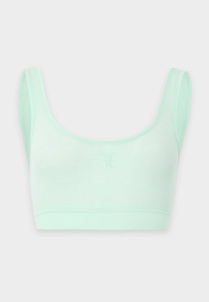 Brassière de sport en tissu côtelé vert clair avec larges bretelles et petit logo brodé au centre devant.