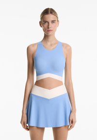 Light blue athletic outfit featuring a fitted top with a round neckline and a flared skirt with cream accents at the waist for contrast.