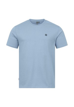 T-shirt azzurro chiaro a maniche corte con scollo rotondo e un piccolo emblema scuro a forma di timone sulla parte sinistra del petto, mostrata su sfondo bianco.