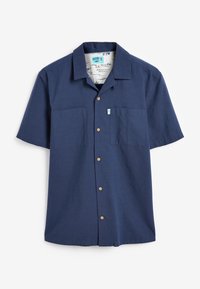 Chemise bleu marine à manches courtes avec col, comportant deux poches avant et des boutons en bois, fabriquée en tissu texturé.