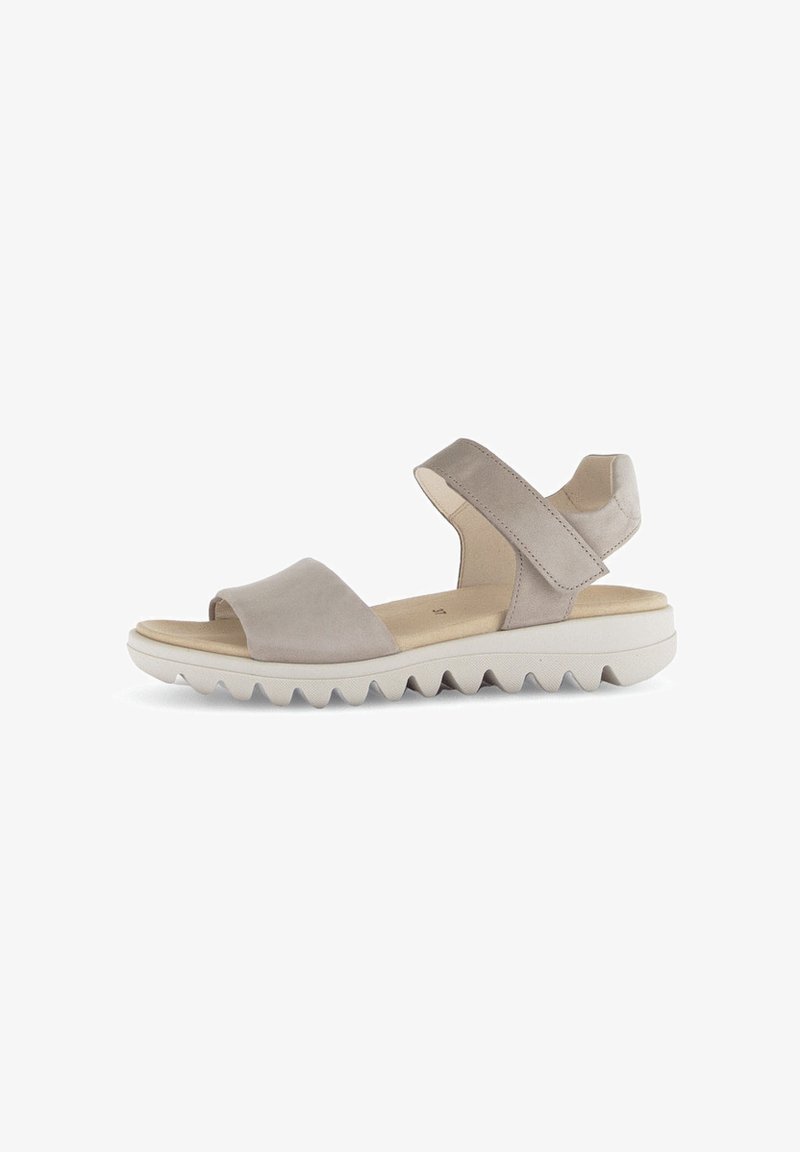 Beige suède sandalen met een kruislings ontwerp, open teen en een verstelbare enkelband. Dikke witte zool met een zigzag profiel.