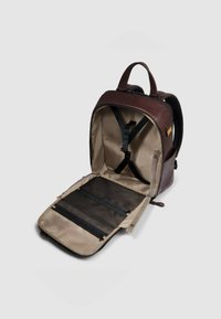 Zaino in pelle marrone con interno color cuoio chiaro. Dotato di spallacci regolabili, un organizer in rete e una chiusura con cerniera. Interno progettato per un facile accesso.