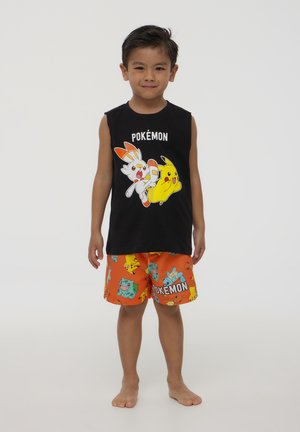 Maglietta nera senza maniche con personaggi Pokémon, abbinata a pantaloni corti arancioni decorati con vari grafica e testi di Pokémon.
