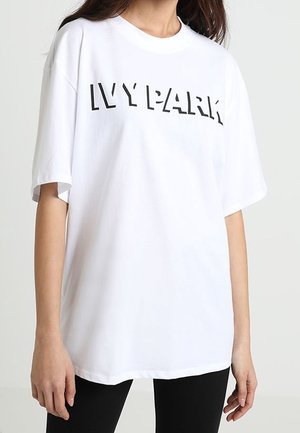 Valkoinen ylisuuri t-paita, joka on valmistettu puuvillasta. Rintamuksessa musta "IVY PARK" -logo. Pyöreä kaula-aukko ja lyhyet hihat.