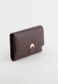 Compact burgundy leather wallet with a textured surface, gold-tone hardware, and a circular clasp detail on the front.