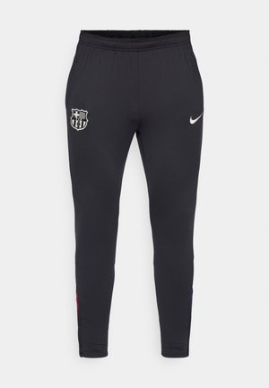 Pantaloni atletici neri con una vestibilità slim, dotati di logo Nike in argento e emblema del FC Barcelona. Il materiale appare liscio con un elastico in vita.