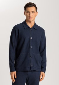 Cárdigan azul marino con botones, fabricado en un tejido suave, con cuello, bolsillos de parche en la parte frontal y seis botones a juego.