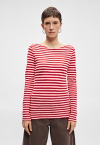 Červené a biele pruhované dlhý rukáv top s lodičkovým výstrihom, vyrobený z mäkkej bavlnenej tkaniny. Má priliehavý strih a úzke rukávy.