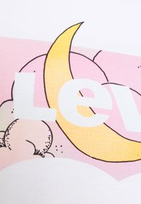 Tissu en coton blanc avec un graphique coloré représentant un croissant de lune jaune et des nuages roses, accompagné du mot "Levi" en lettres blanches en gras.