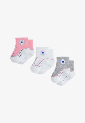 Tri par paraanklnih nogavic: roza z belimi poudarki, bela z modrim obrisom in siva z rdečim obrisom. Vse nosijo logo Converse.