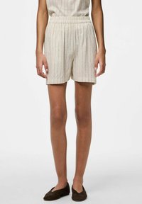 Pantaloni corti in lino color beige chiaro con sottili righe verticali, dotati di una vita elasticizzata e di una vestibilità ampia, che arrivano a metà coscia.