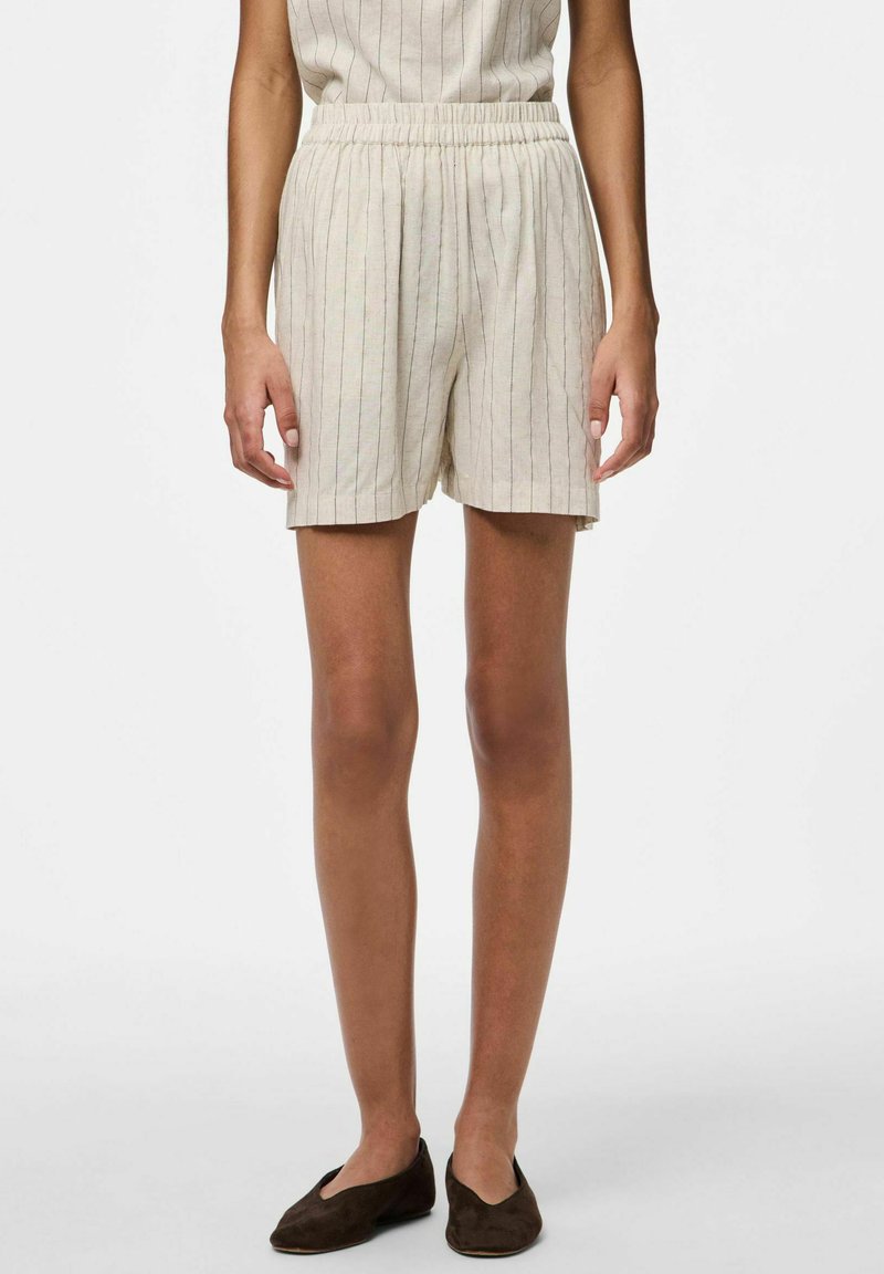 Pantaloni corti in lino color beige chiaro con sottili righe verticali, dotati di una vita elasticizzata e di una vestibilità ampia, che arrivano a metà coscia.