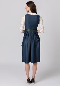 Navy blue dress with a fitted bodice, pleated skirt, and green sash at the waist. Features sheer lace long sleeves and a smooth texture.