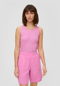 Roze mouwloos topje en bijpassende roze shorts van een gestructureerde stof. De shorts hebben een elastische tailleband en zijzakken.
