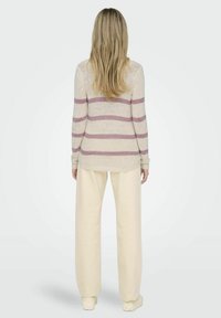 Helles beige Sweatshirt mit lavendelfarbenen Streifen, langen Ärmeln und einer lockeren Passform, kombiniert mit cremefarbenen weit geschnittenen Hosen und Stricksocken.
