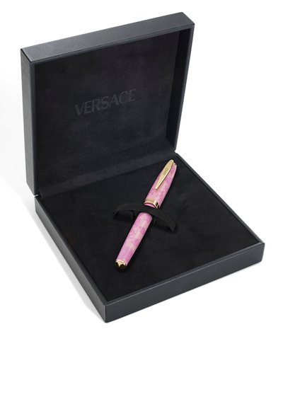 Crna kutija obložena baršunom s logotipom Versace sadrži ružičastu i zlatnu nalivpero pričvršćenu crnim remenom.