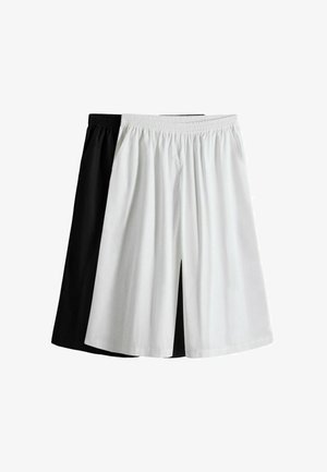 Zwei Paare lockere knielange Shorts mit elastischem Bund, ein weißes vorne und ein schwarzes hinten auf weißem Hintergrund.