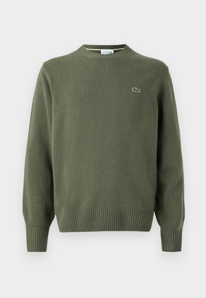 Olive green knit sweater featuring a round neckline, ribbed cuffs, and hem, with a small embroidered logo on the left chest.