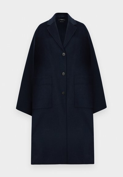 Long dark navy wool coat with wide sleeves, three front buttons, notch collar, and two large patch pockets.