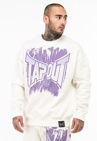 Cremefarvet sweatshirts med et iøjnefaldende lila TAPOUT grafisk design med en struktureret overflade. Den har en afslappet pasform og ribbede manchetter for komfort.