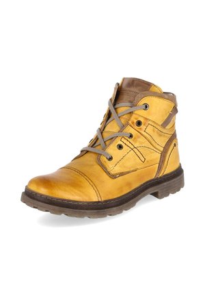 Bota de cuero amarillo hasta el tobillo con suela marrón y cordones grises, con detalles cosidos y ojales metálicos sobre fondo blanco.