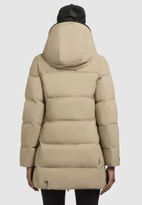 Beige gewatteerde parka-jack met een grote capuchon, gequiltde textuur en zwarte accenten. Heeft een rechte silhouet en zijzakken voor de handen.