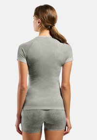 Light gray athletic top with short sleeves, textured mesh design, and seamless construction, paired with matching shorts.