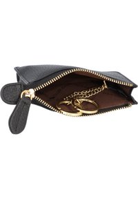 Zwarte leren tas met textuur en een gouden ritssluiting, met een ketting met sleutelhangers binnenin en een bruine stofvoering.