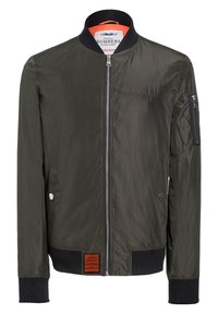 Bomberjacka i mörkgrön nylon med dragkedja fram, ribbade cuffar och nederkant, sidofickor och ett orange foder. Har en logotyp på bröstet.