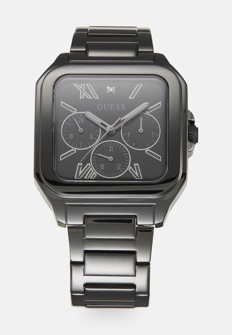 Montre analogique carrée noire avec accents en argent, trois sous-cadrans et un bracelet en maillons métalliques. Comprend des chiffres romains et un affichage de la date.