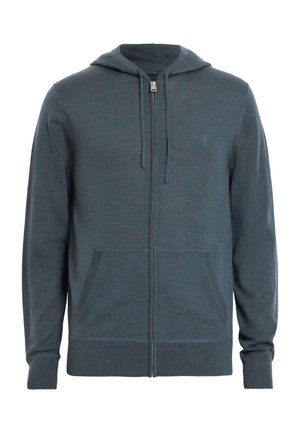 Donkergroene rits-hoodie gemaakt van een zachte, gestructureerde stof. Voorzien van een gevoerde capuchon, voorkeurszakken en ribgebreide manchetten en zoom.