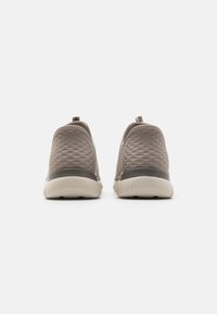 Grey slip-on sneakers with a textured, quilted upper and a white, cushioned sole. Features a loop on the heel for easy wear.