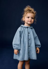 Helles blaues Denim-Kleid mit einem runden Kragen, Knopfverschluss und Puffärmeln. Der Stoff hat eine weiche Textur und eine lockere Passform.