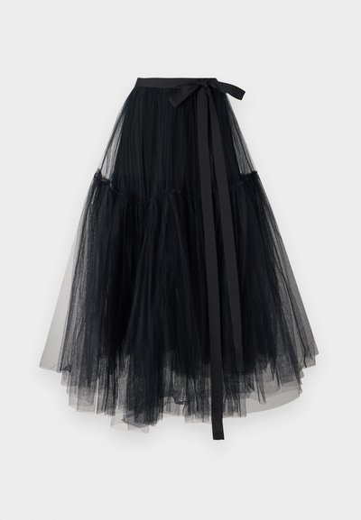 Black tulle skirt with a fitted waistband and a tied ribbon accent. Features layered, flowing fabric creating a full silhouette. Lightweight texture.