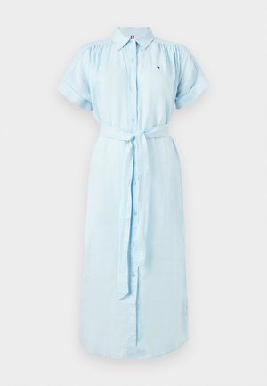 Svijetloplava haljina s kratkim rukavima i gumbima sprijeda, sa naboranim ramenima, pojasom za vezanje u struku i malim logotipom na prsištu.