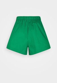 Zelené bavlněné šortky s elastickým pasem, mají volný střih a hladkou texturu. Jednoduchá, jednobarevná bez vzorů nebo akcentů.
