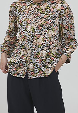Blusa floreale nera, caratterizzata da motivi di fiori multicolori, maniche a sbuffo e scollatura rotonda, abbinata a pantaloni scuri.