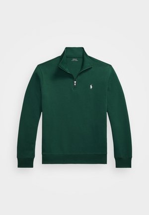 Grön tröja med kvartdragkedja, ribbade ärmslut och en liten broderad logotyp på bröstet. Tillverkad av mjukt, slätt material.