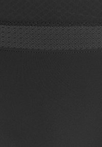 Black fabric with a smooth texture, featuring a darker mesh panel at the top. Simple design, no visible patterns or embellishments.