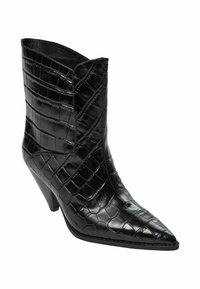 Čierna kožená členková čižma s špicatou špičkou, zdobená textúrou krokodílej kože a zakriveným horným okrajom. Podpätok na ihlu pridáva výšku.