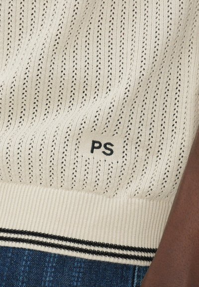 Šviesiai rudas megztinis su vertikalia glotnybe ir atvira pynimo struktūra, turintis juodą "PS" etikETĘ ir kontrastinę juodą juostą ant apačios.