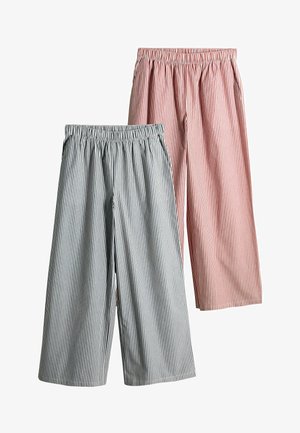 Deux paires de pantalons à taille élastique rayés, l'une grise et blanche, l'autre rouge et blanche, toutes deux à jambe large avec des poches latérales.